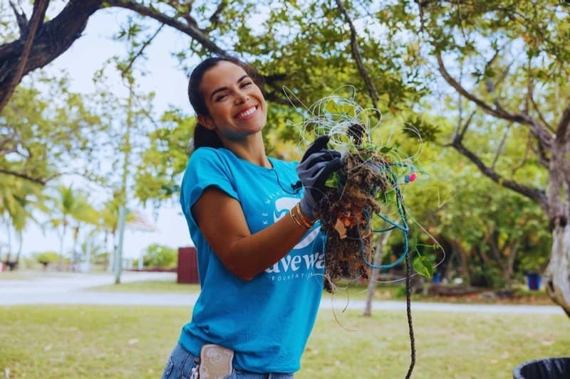 Kelly Angel holding up fishing line and debris pulled out of the water at a Miami cleanup